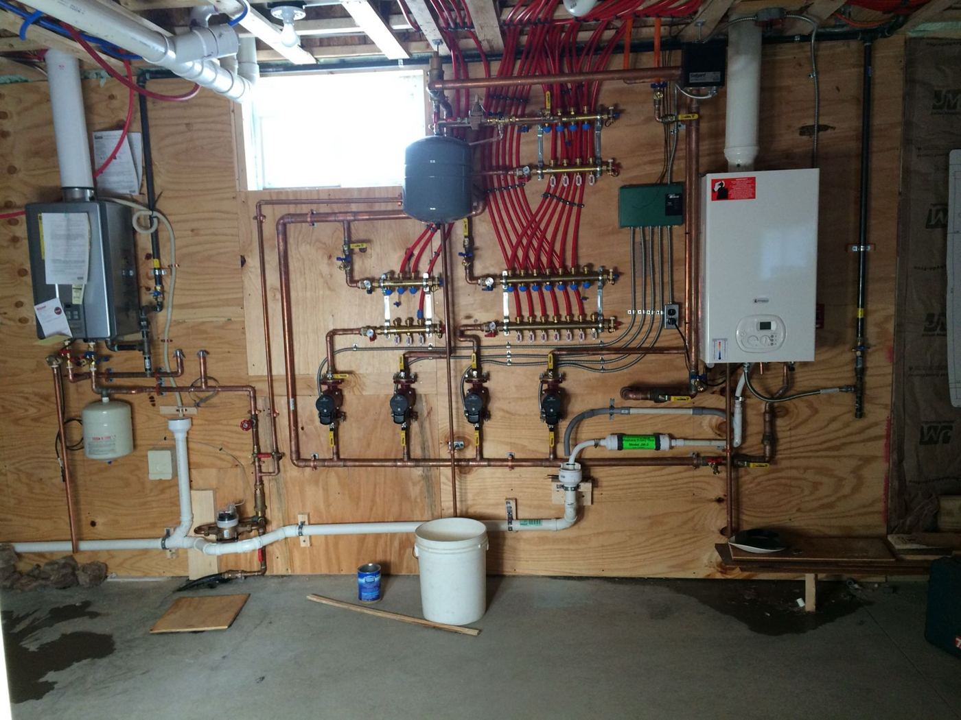 Boiler room with a wall-hung boiler, circulator pumps and radiant heat manifolds