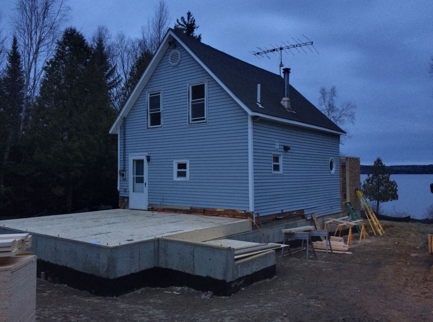 Lakeside camp on a new foundation with an addition being framed