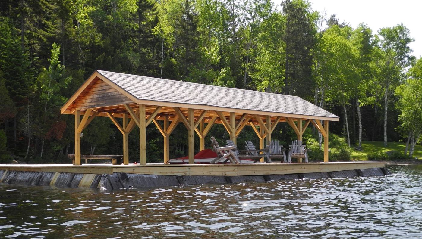 Covered dock with timber-frame roof on the lake in summer
