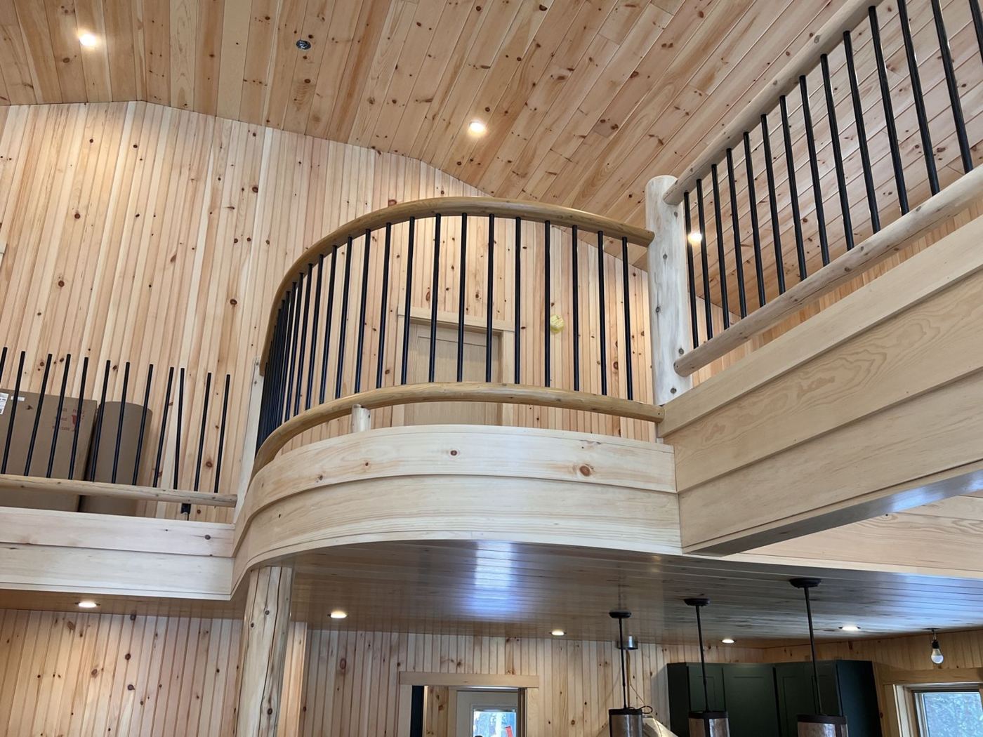 Curved balcony with log railing over the kitchen