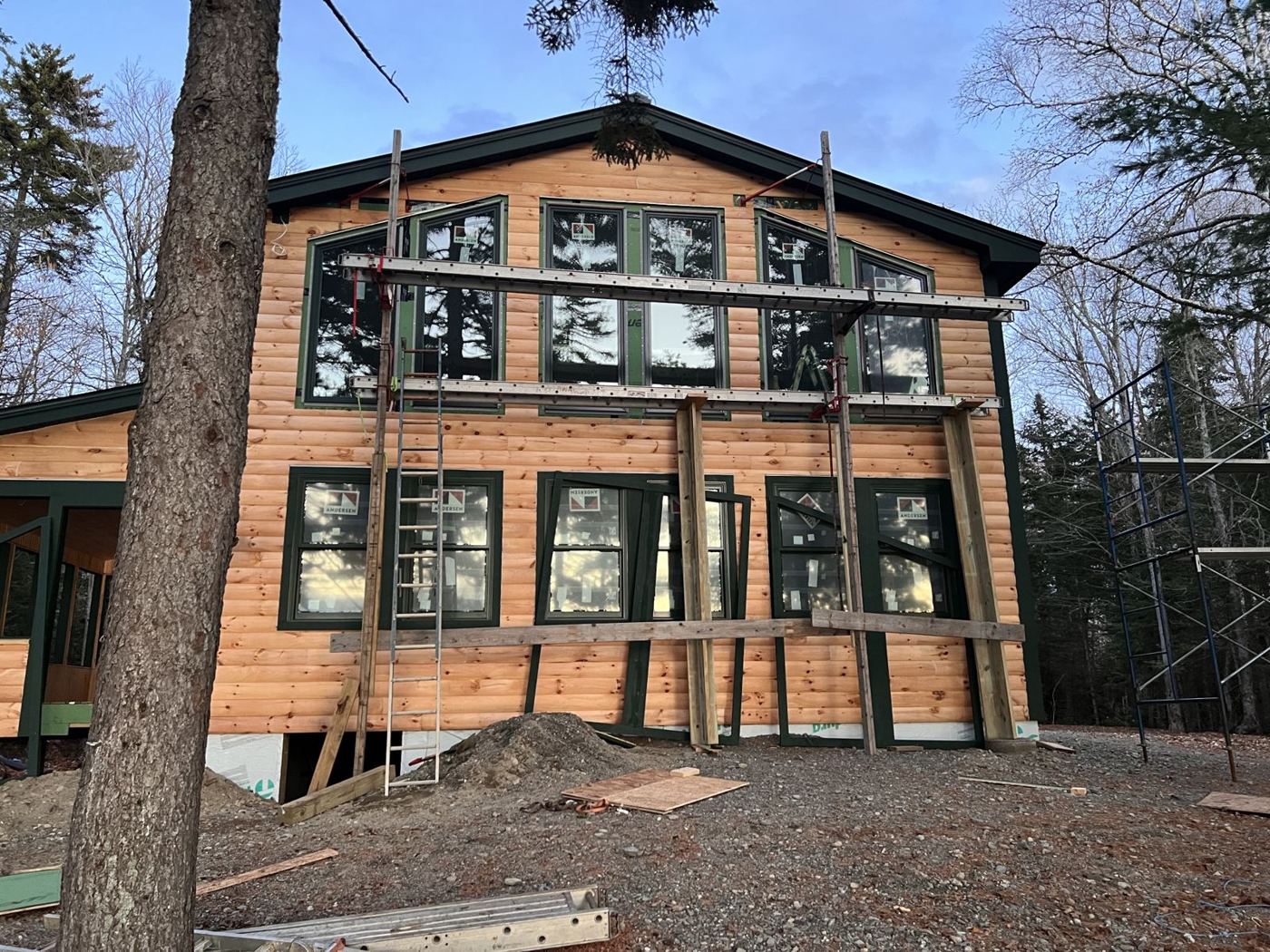 Gable end with log siding and tall Andersen windows