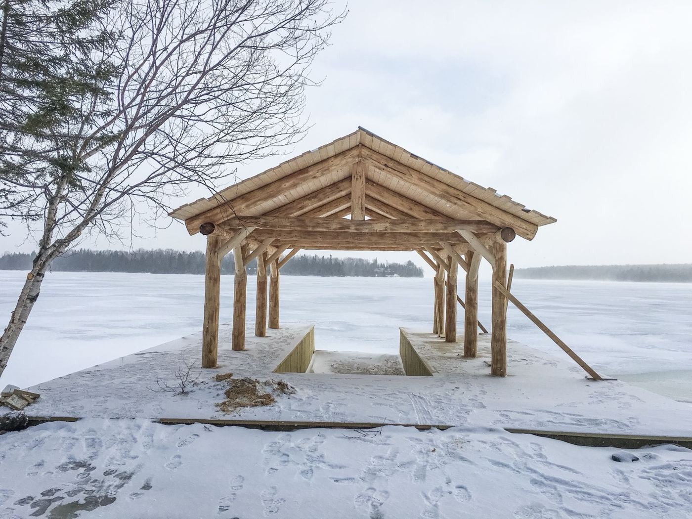 Log-frame boathouse on the frozen lake
