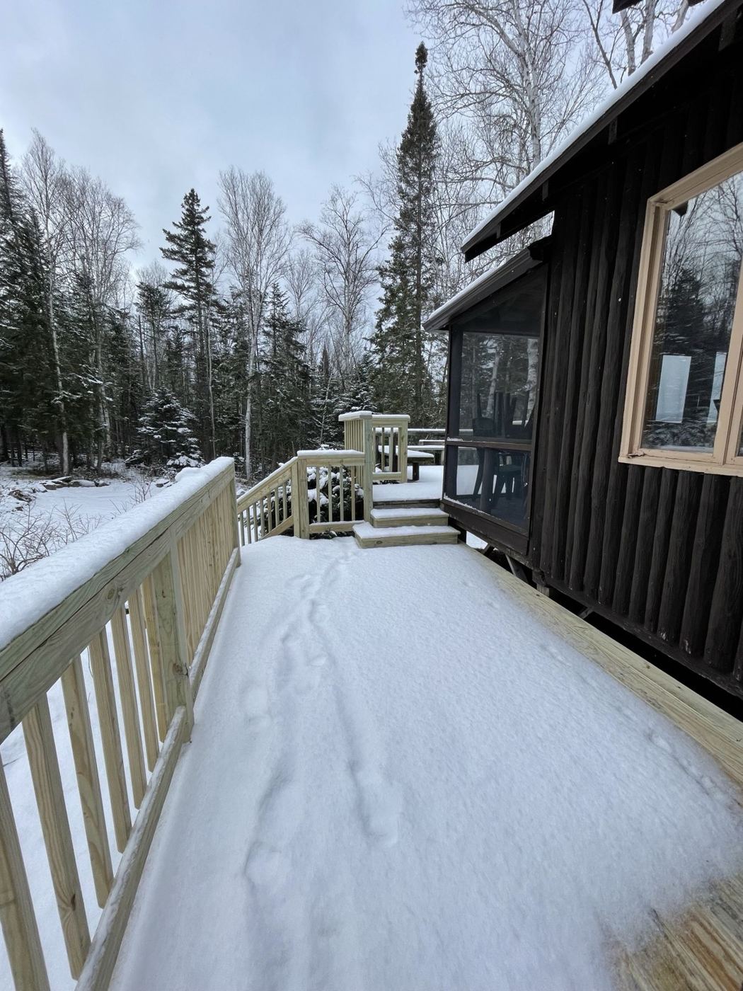 New deck, stairs and railings along a dark-stained camp