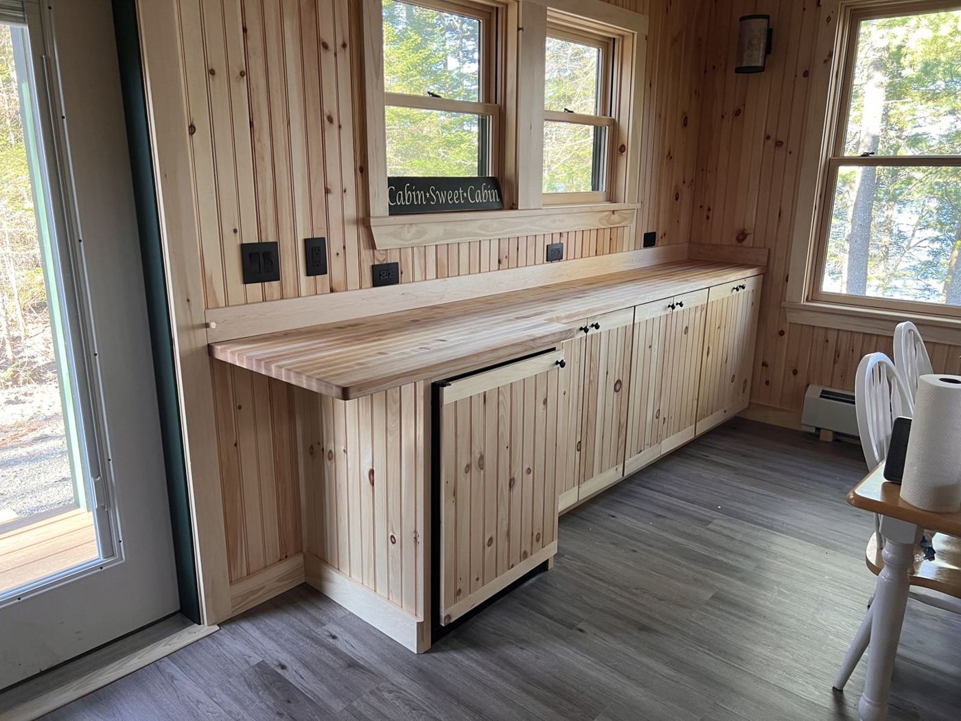 Custom pine cabinets with a butcher-block counter under the windows