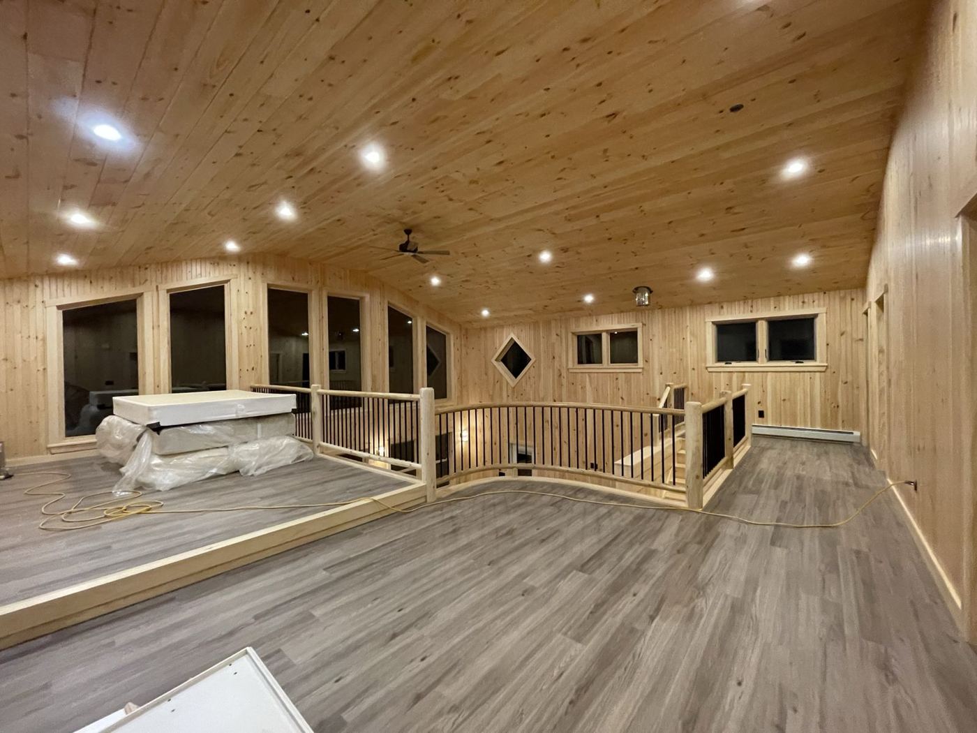 Upstairs loft with pine ceiling and curved log railing