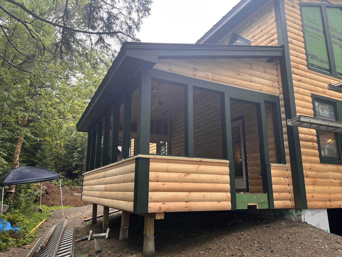 Screened porch with log siding and green trim