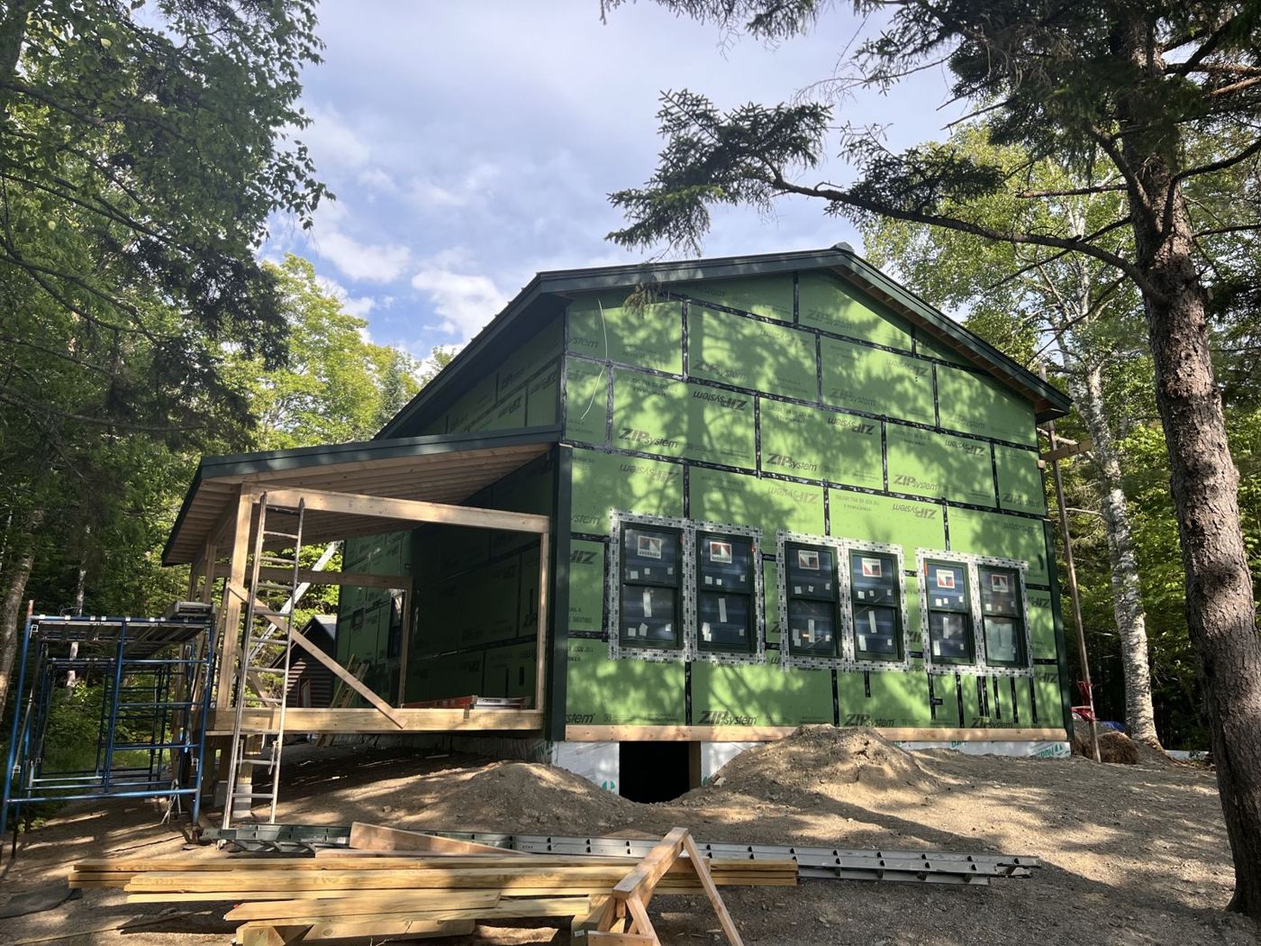 House wrapped in green ZIP System sheathing with new windows